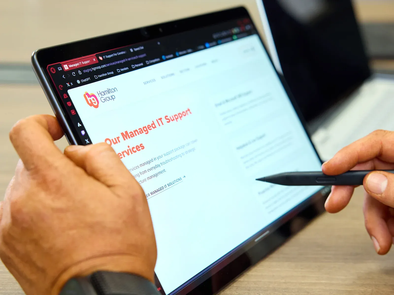 Close-up of a tablet displaying the Hamilton Group Managed IT Support Services page.