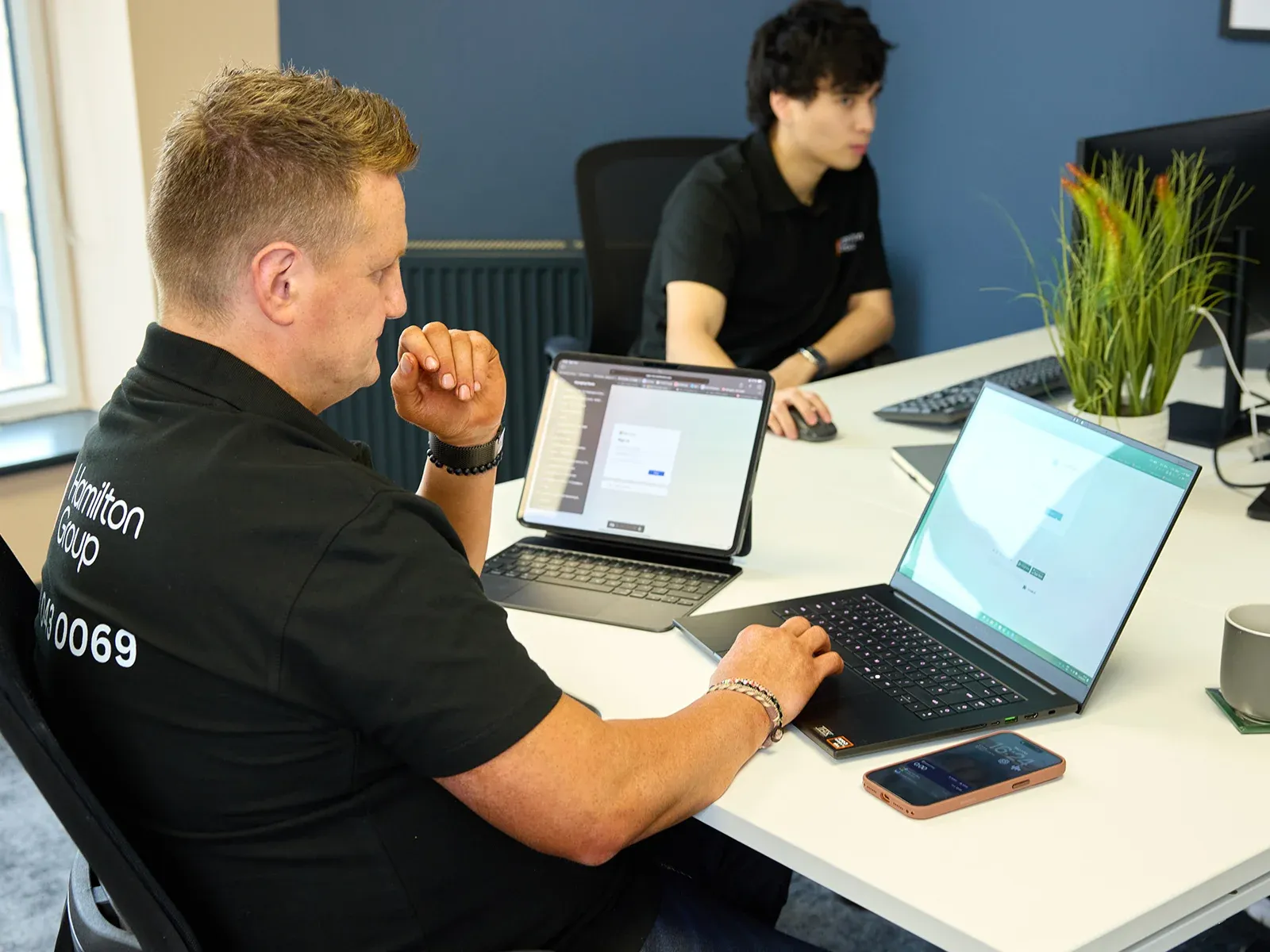 Hamilton Group team members working at laptops in the office.